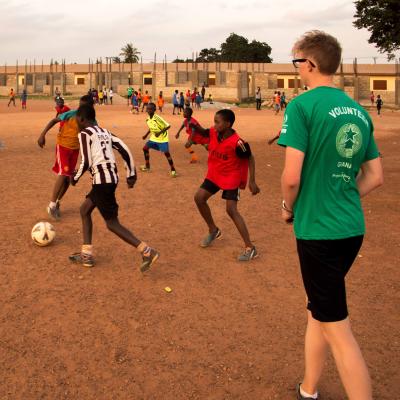 Juego de práctica durante nuestro voluntariado como entrenador de fútbol en Ghana. Voluntario practicando con sus jugadores.